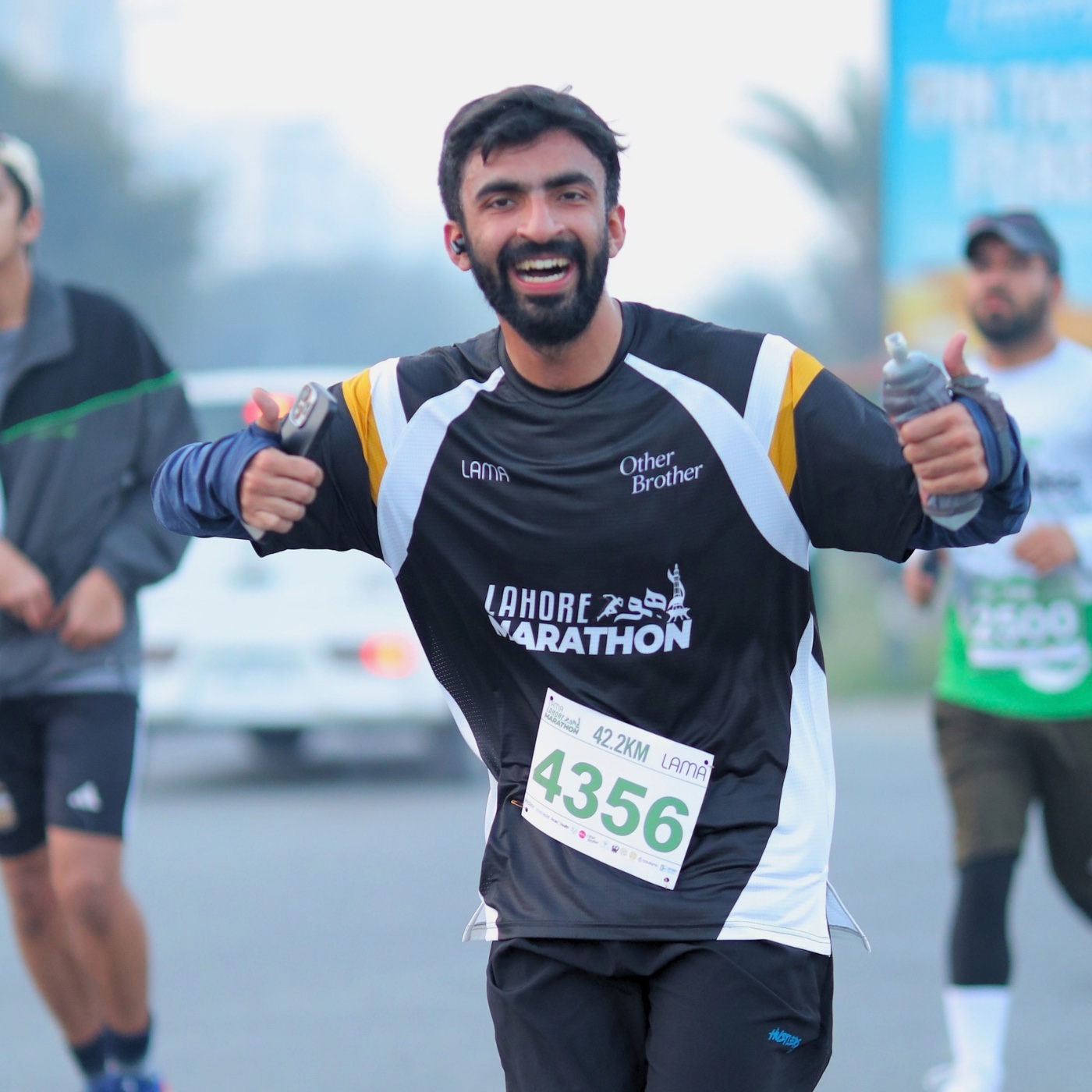 A smiling Lahore Marathon runner giving two thumbs up, bib 4356