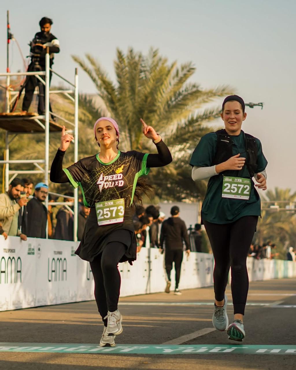 Two women runners finishing together on the closing stretch