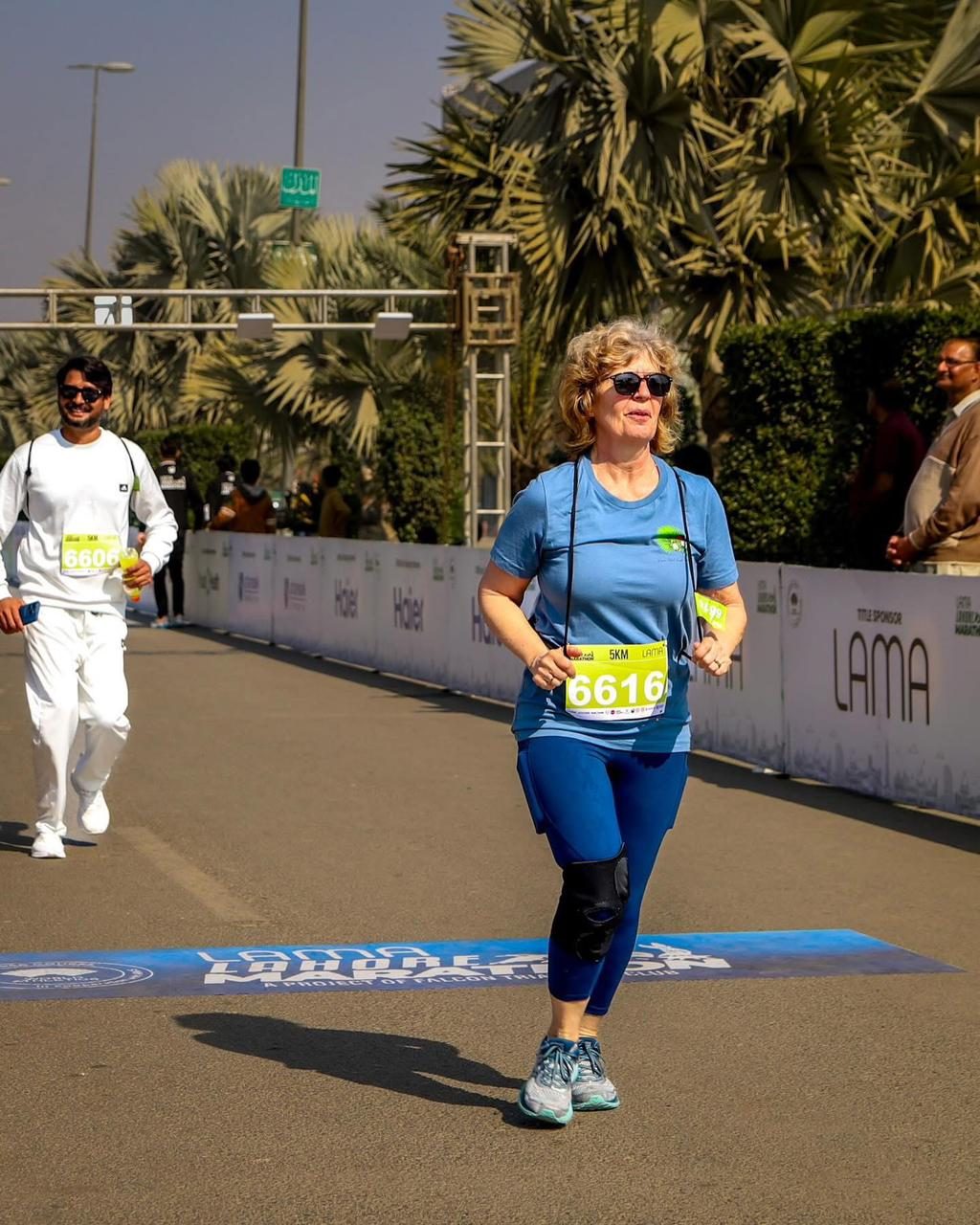 An older woman in blue running the 5K
