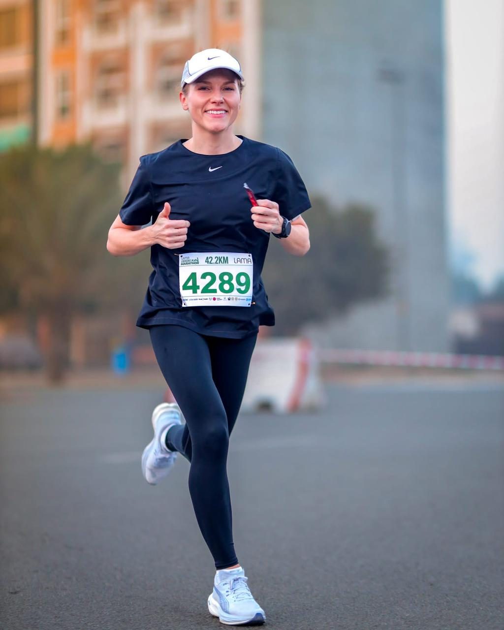 A smiling woman in navy running the marathon